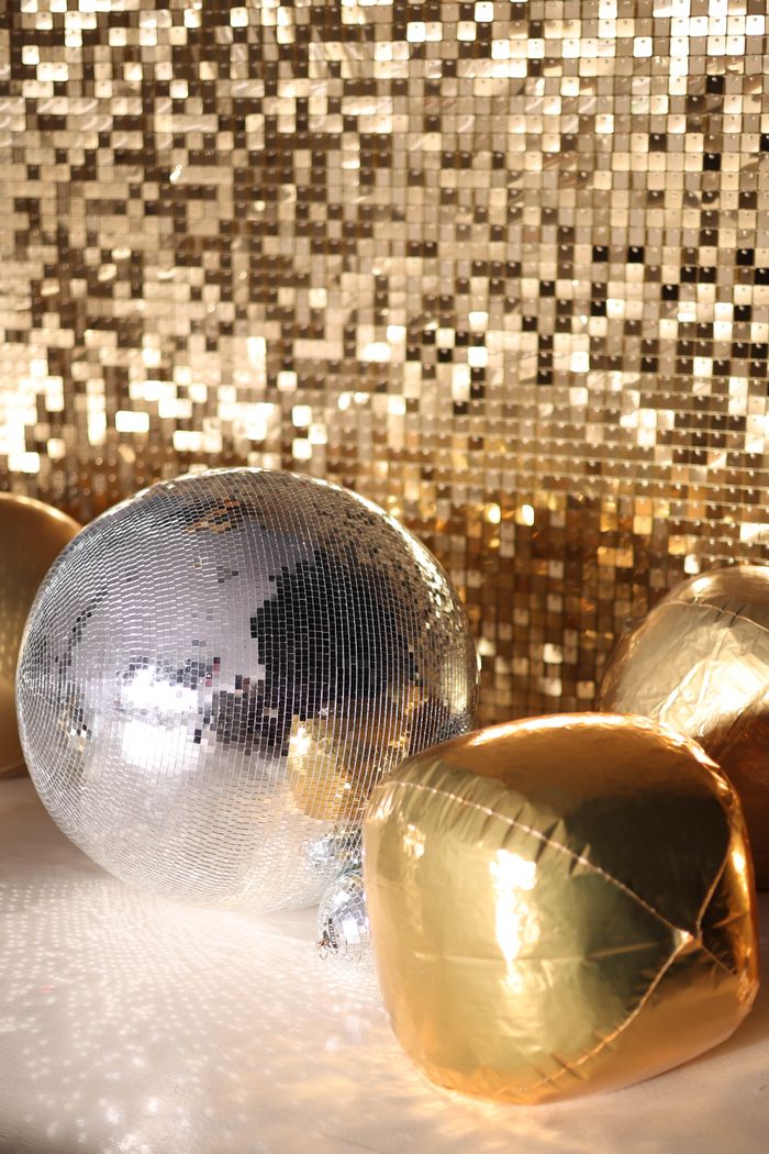 Sparkling disco ball with shimmering gold decor, perfect for party ambiance and night events.
