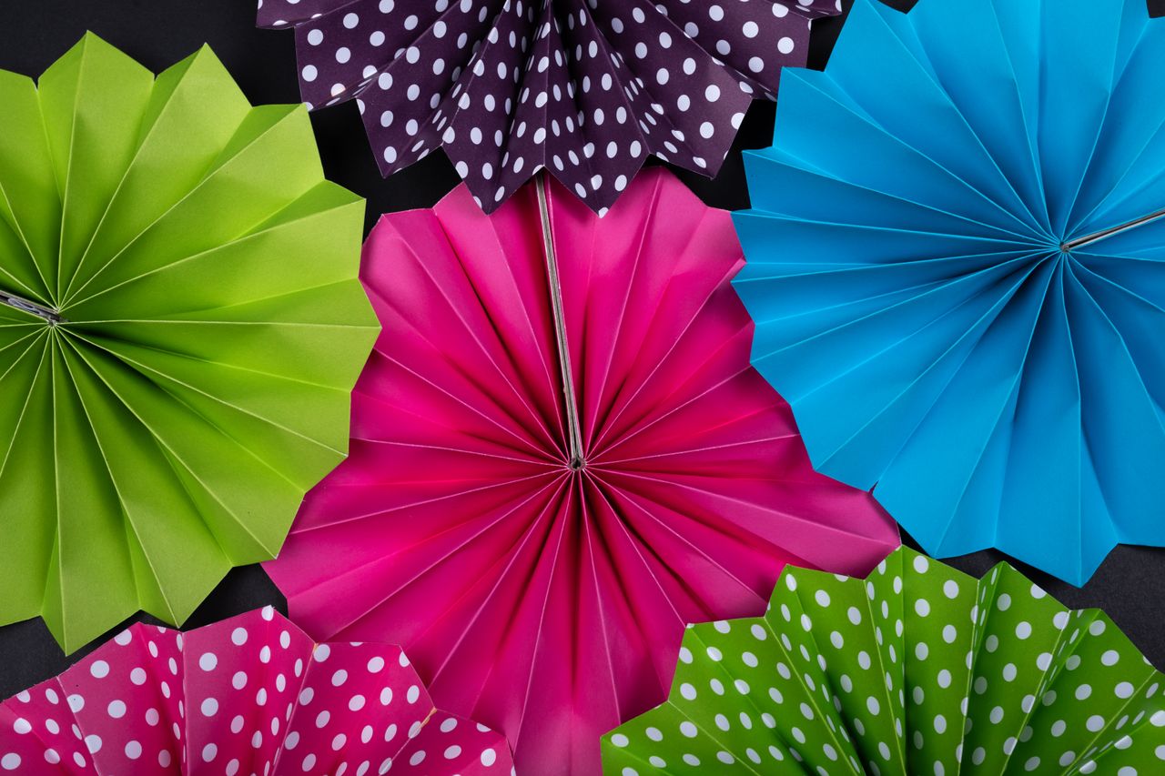 Bright and colorful origami paper fans create a vibrant decoration display.